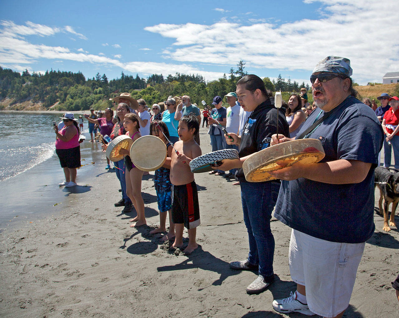 Drummers greet the canoe from the Nisqually Tribe as they land at Fort Wooden State Park on Saturday. (Steve Mullensky/for Peninsula Daily News)