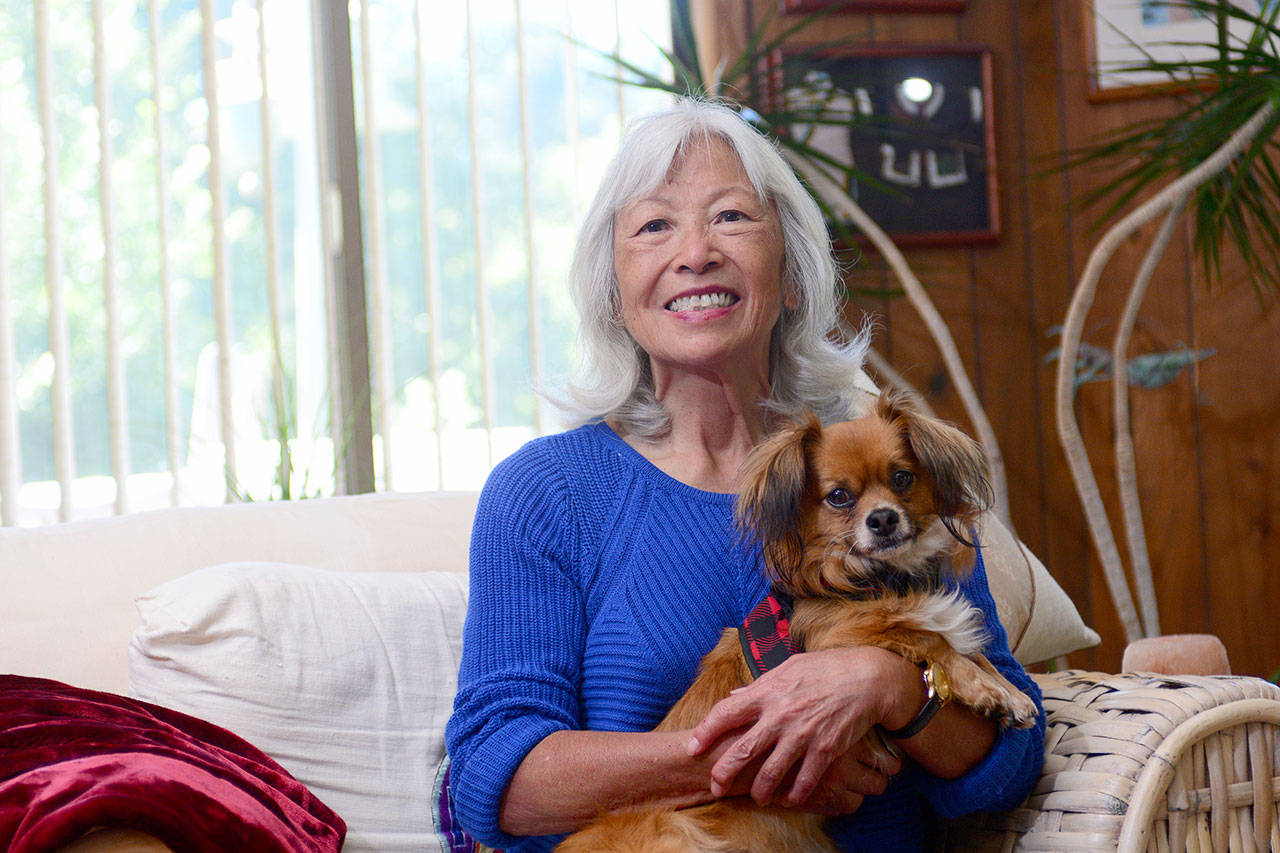 Sajean Geer of Port Angeles, 71, sits in her home Monday with her terrier-Chihuahua, Yoda, after surviving six days with only her dog in the Olympic National Park wilderness. Geer was rescued Sunday evening. (Jesse Major/Peninsula Daily News)