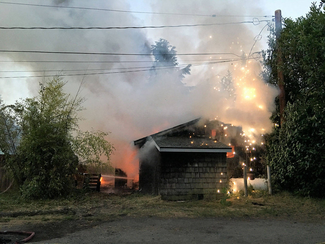 A power line sparks near a house fire on the 200 block of Hancock Street in Port Townsend on Sunday morning. (Bill Beezley/East Jefferson Fire-Rescue)