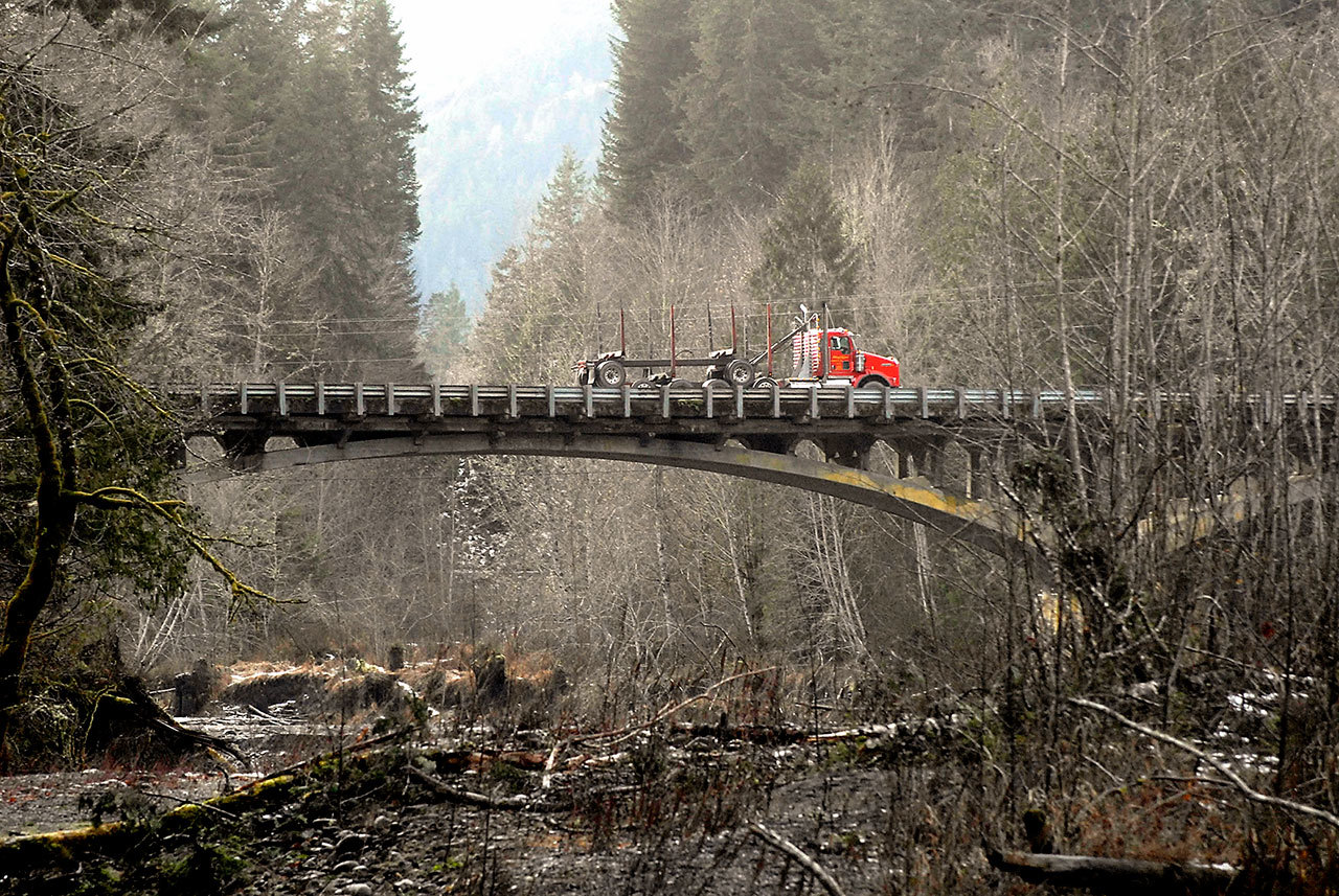 A logging truck makes its way across the U.S. Highway 101 bridge over the Elwha River west of Port Angeles last year. (Keith Thorpe/Peninsula Daily News)