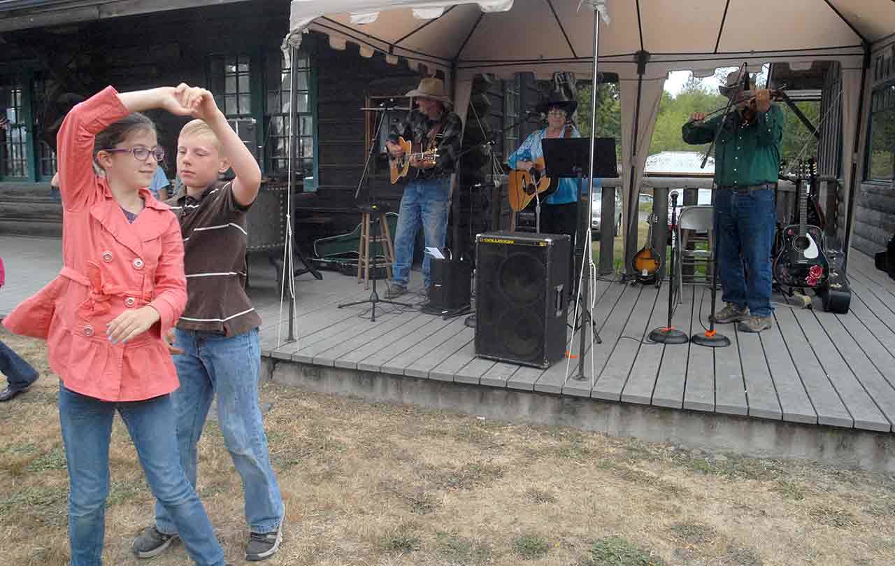 Siblings Adam Chloe Corey and Adam Corey, both 11 of Port Angeles, dance to the music of Wanda Bumbarner & Friends on the lawn of the Joyce Museum last year during Joyce Daze. (Keith Thorpe/Peninsula Daily News)