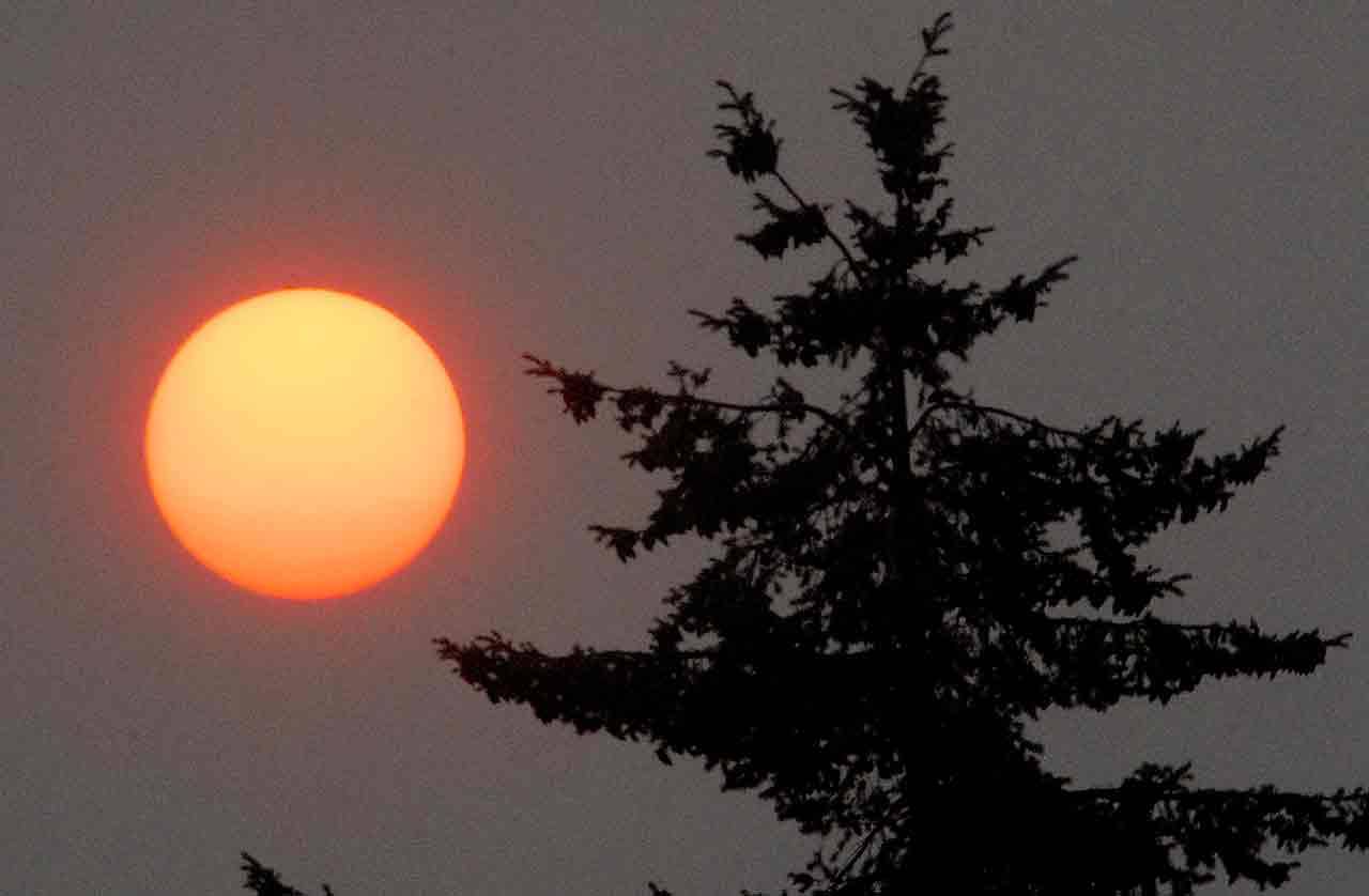 The setting sun, as seen from Port Angeles, glows orange and red as it filters through layers of smoke from British Columbia wildfires that drifted south over the North Olympic Peninsula on Tuesday. (Keith Thorpe/Peninsula Daily News)