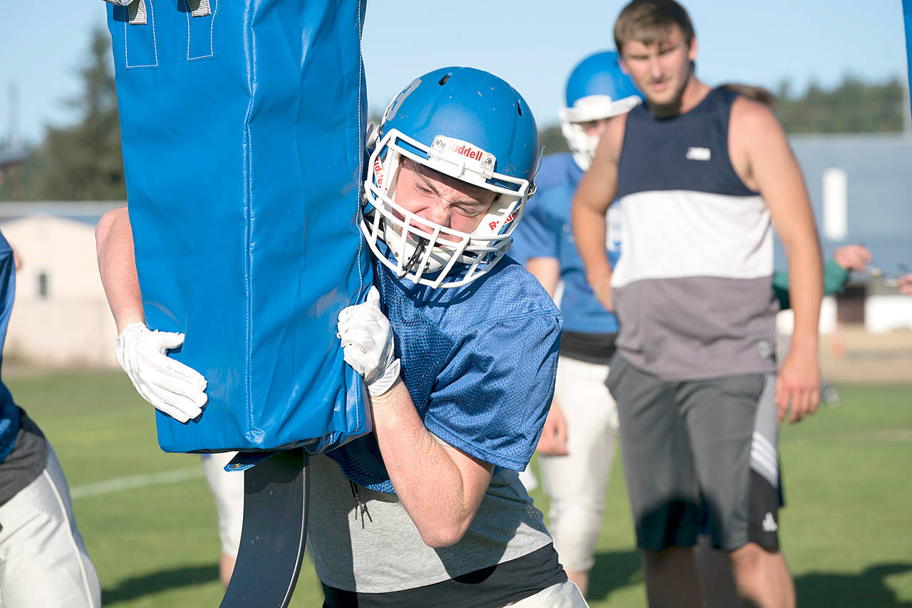 Chimacum’s Isaac Purser hits the tackling sled during a recent preseason practice. Steve Mullensky/for Peninsula Daily News