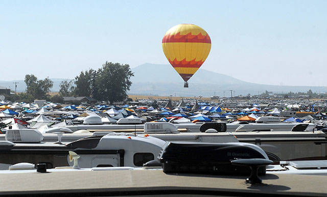 A hot air balloon rises over Solartown, an encampment serving as a temporary home to tens of thousands of eclipse watchers Sunday morning in Madras, Ore. The site is located at the center of the swath of shadow of a total solar eclipse today that will trace a path from Oregon to South Carolina. (Keith Thorpe/Peninsula Daily News)