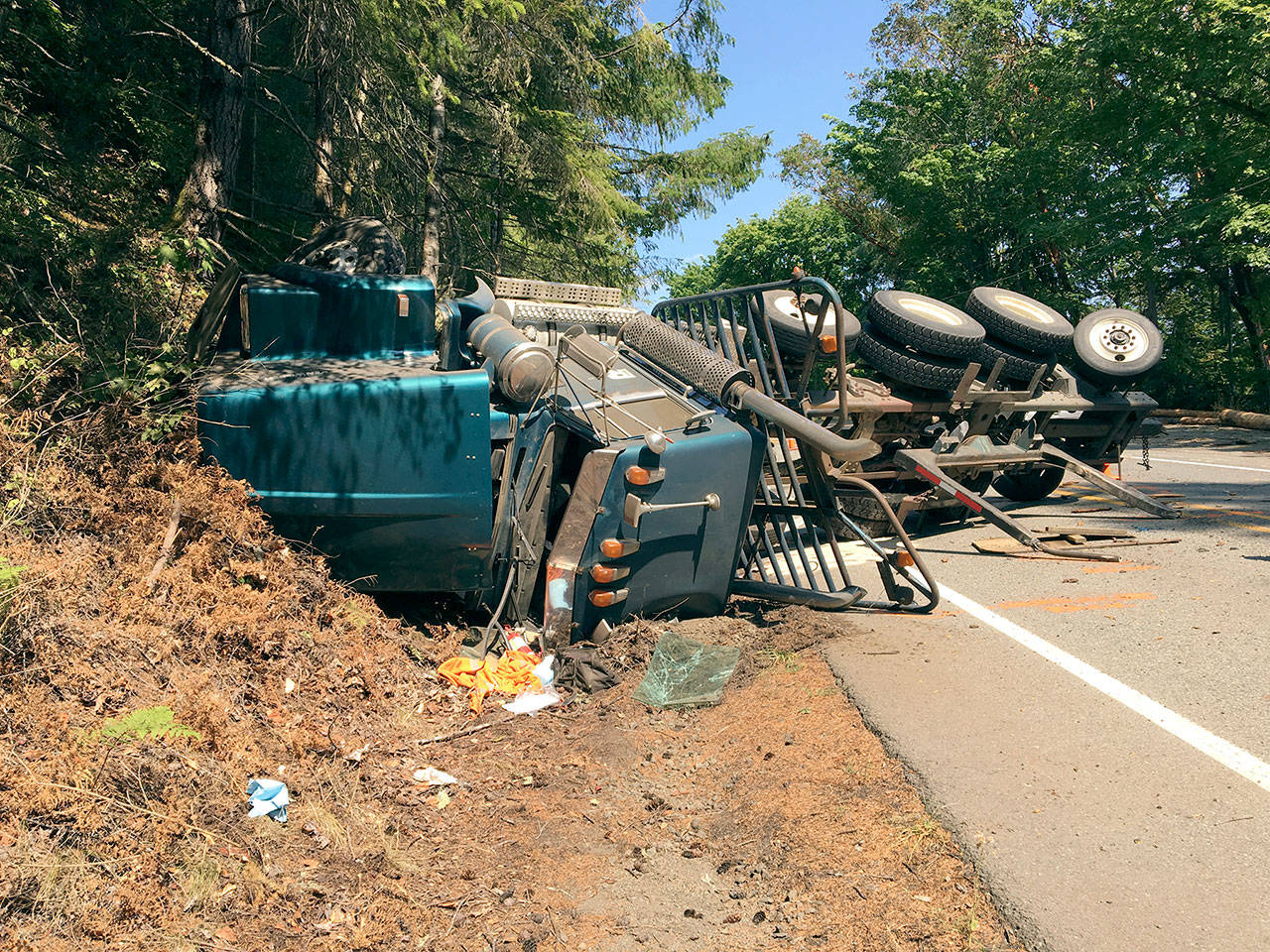 A log truck rolled over on U.S. Highway 101 near Brinnon on Monday, impacting traffic on the highway for roughly four hours. (Trooper Russ Winger/Washington State Patrol)