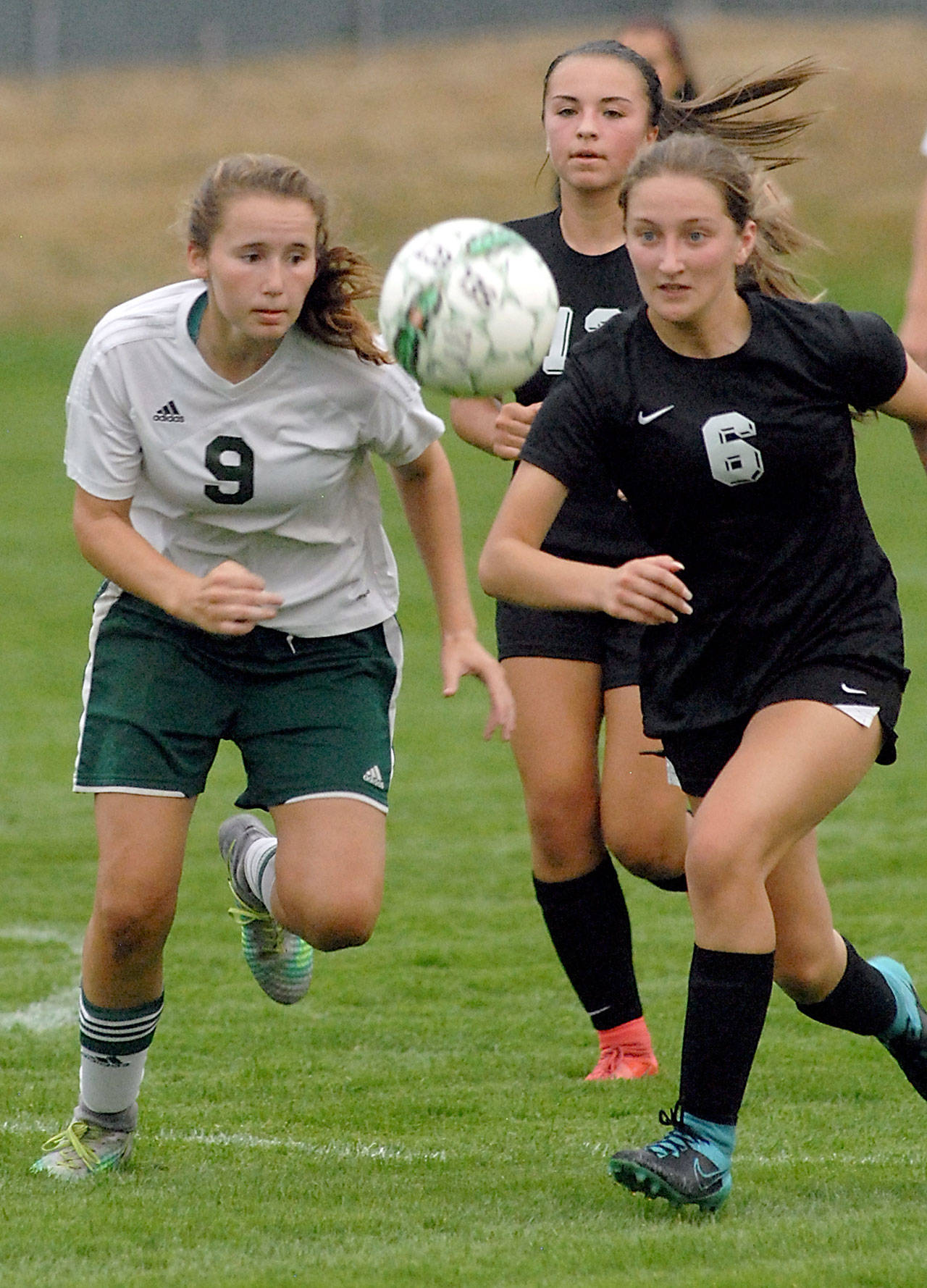 Port Angeles’ Delaney Wenzl, left, and Klahowya’s Gabrielle Marcoux chase after the ball during first-half action on Tuesday at Port Angeles Civic Field. Following the play from behind is Klahowya’s Rylee Radford. (Keith Thorpe/Peninsula Daily News)