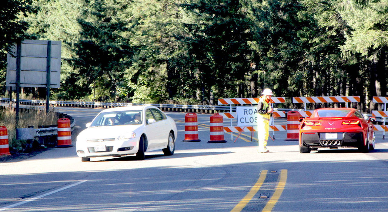 Strider Construction employee Sarah Welchel of Port Angeles tells drivers that U.S. Highway 101 is closed at the intersection with the East Beach Road near Lake Crescent for as much as four days. (Dave Logan/for Peninsula Daily News)