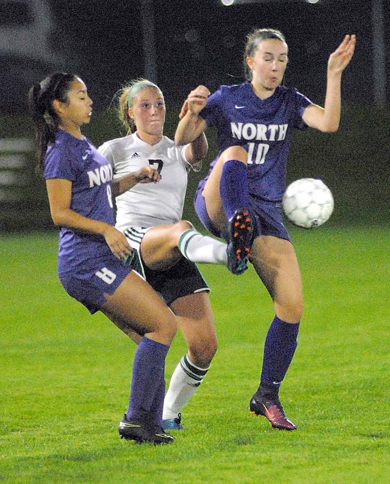 Keith Thorpe/Peninsula Daily News                                Port Angeles’ Kyrsten McGuffey, center, is sandwiched by the defense of North Kitsap’s Alaina Marcotte, left, and Audrey Zinn in the first half of Tuesday night’s match at Port Angeles Civic Field.