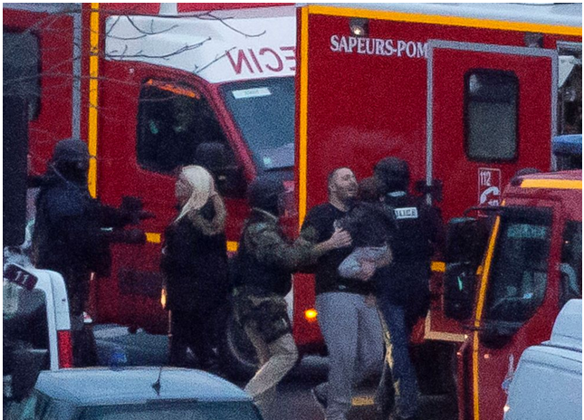 A security officer directs released hostages after they stormed a kosher market to end a hostage situation in Paris (The Associated Press)