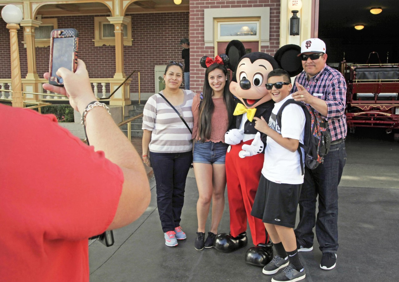 Visitors pose with Mickey Mouse at Disneyland in Anaheim