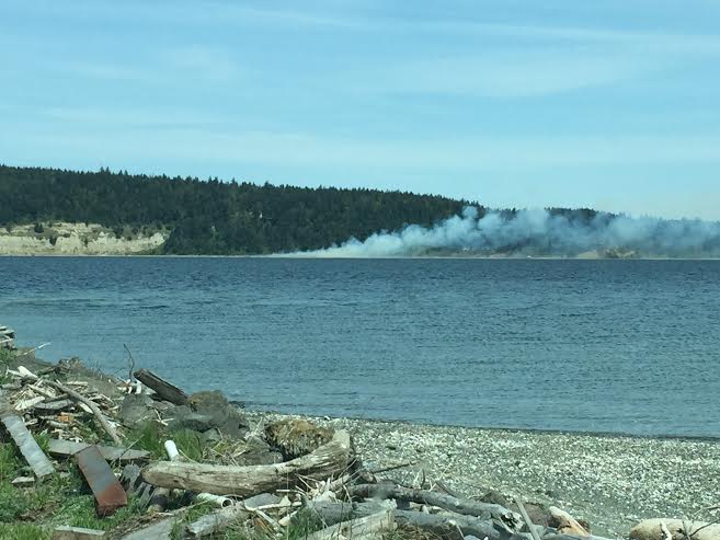 Smoke can be seen across Discovery Bay from a beach fire near Cape George Road. (Joe D'Amico)