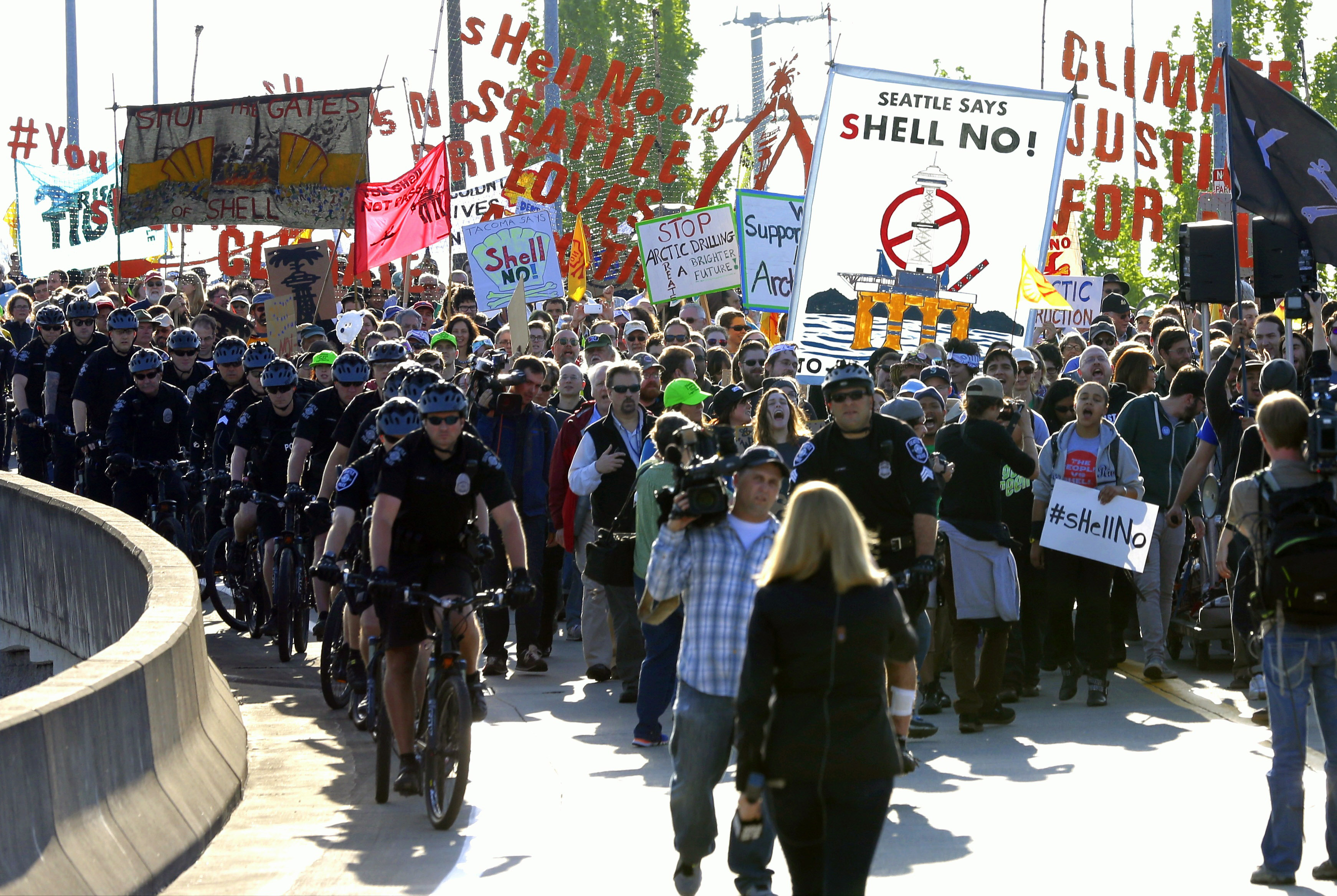 Protesters accompanied by Seattle police officers on bicycles march at the Port of Seattle on Monday. (The Associated Press (Click on image to enlarge))