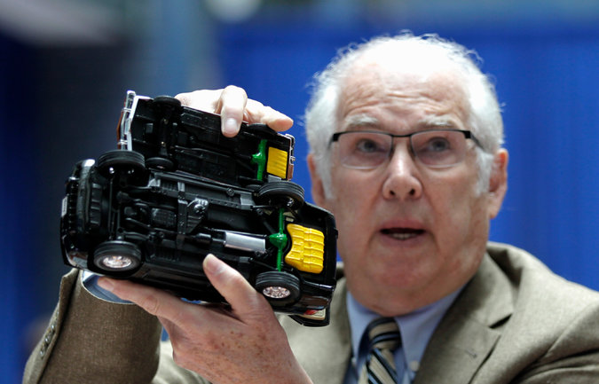 Auto safety expert Byron Bloch holding up models of a Ford Pinto and a Jeep Grand Cherokee SUV during a Transportation Department hearing into Fiat Chrysler Automobiles