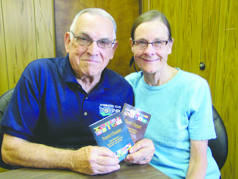 Ron and Betsy Snipe of Port Angeles with their Traveler's Passport guidebooks. Arwyn Rice/Peninsula Daily News