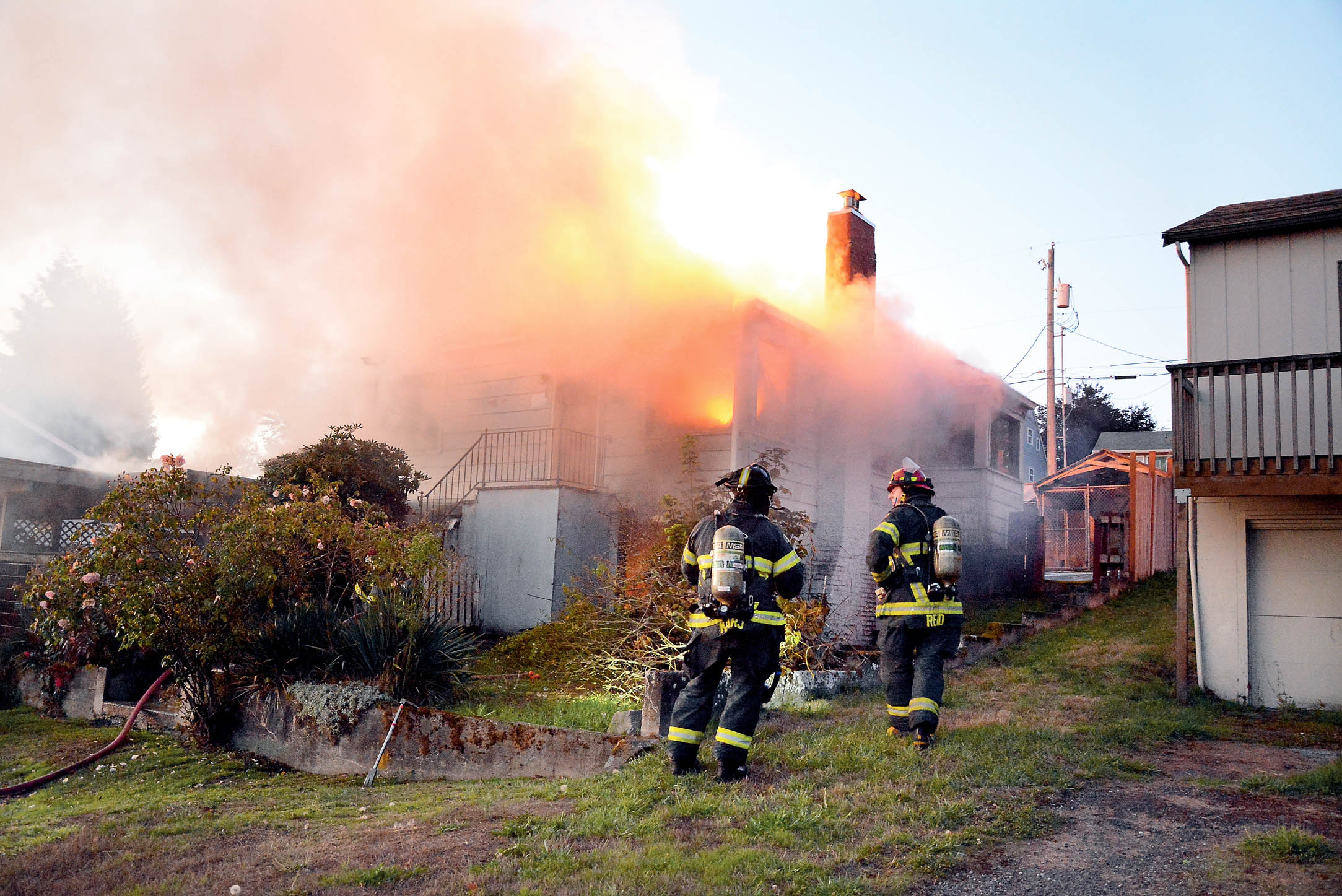 Firefighters battle the house fire at 218 E. Lopez Ave. in Port Angeles this morning. Jay Cline