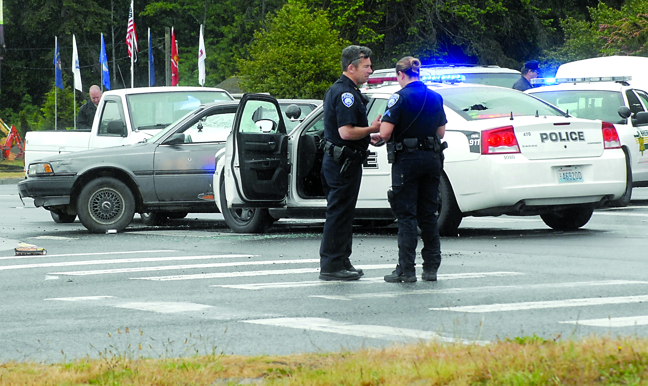 Port Angeles police Interim Chief Brian Smith confers with Cpl. Kori Malone at the scene of an officer-involved shooting after a short police chase that ended at U.S. Highway 101 and Monroe Road east of Port Angeles on Saturday morning. (Keith Thorpe/Peninsula Daily News)