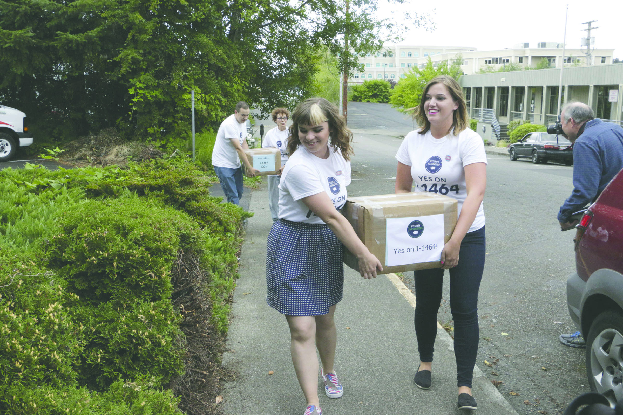 Supporters of a proposed campaign finance reform ballot measure carry boxes of signed petitions to turn in Friday in Olympia. (The Associated Press)