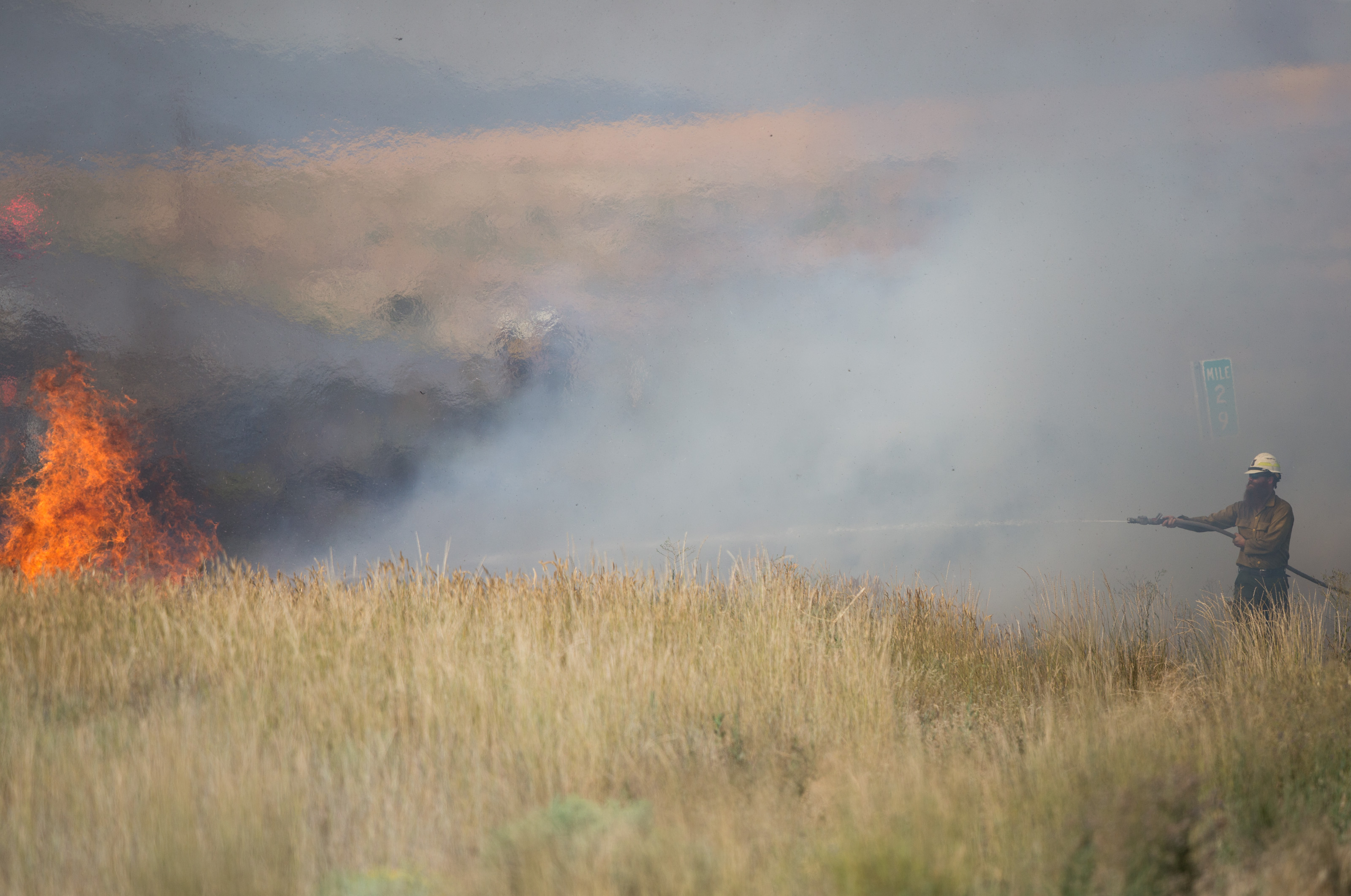 National Forest Service firefighter Blake Nelson works to contain a brush fire off of State Route 24 near Moxee