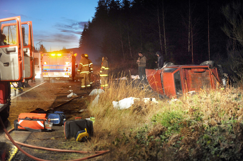 A pickup truck is overturned Thursday morning on U.S. Highway 101 near Bear Creek. (Lonnie Archibald/for Peninsula Daily News)