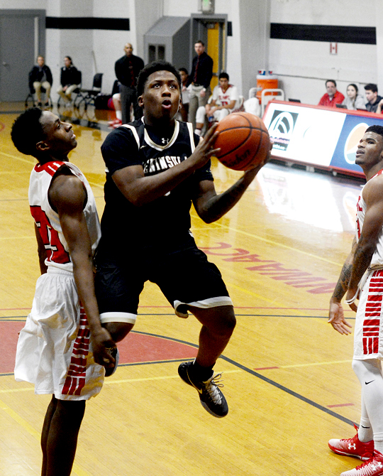 Peninsula's Darrion Daniels goes for a layup against Olympic's Noah Spearman. Daniels led the Pirates with 20 points. (Rick Ross/Peninsula College Athletics)