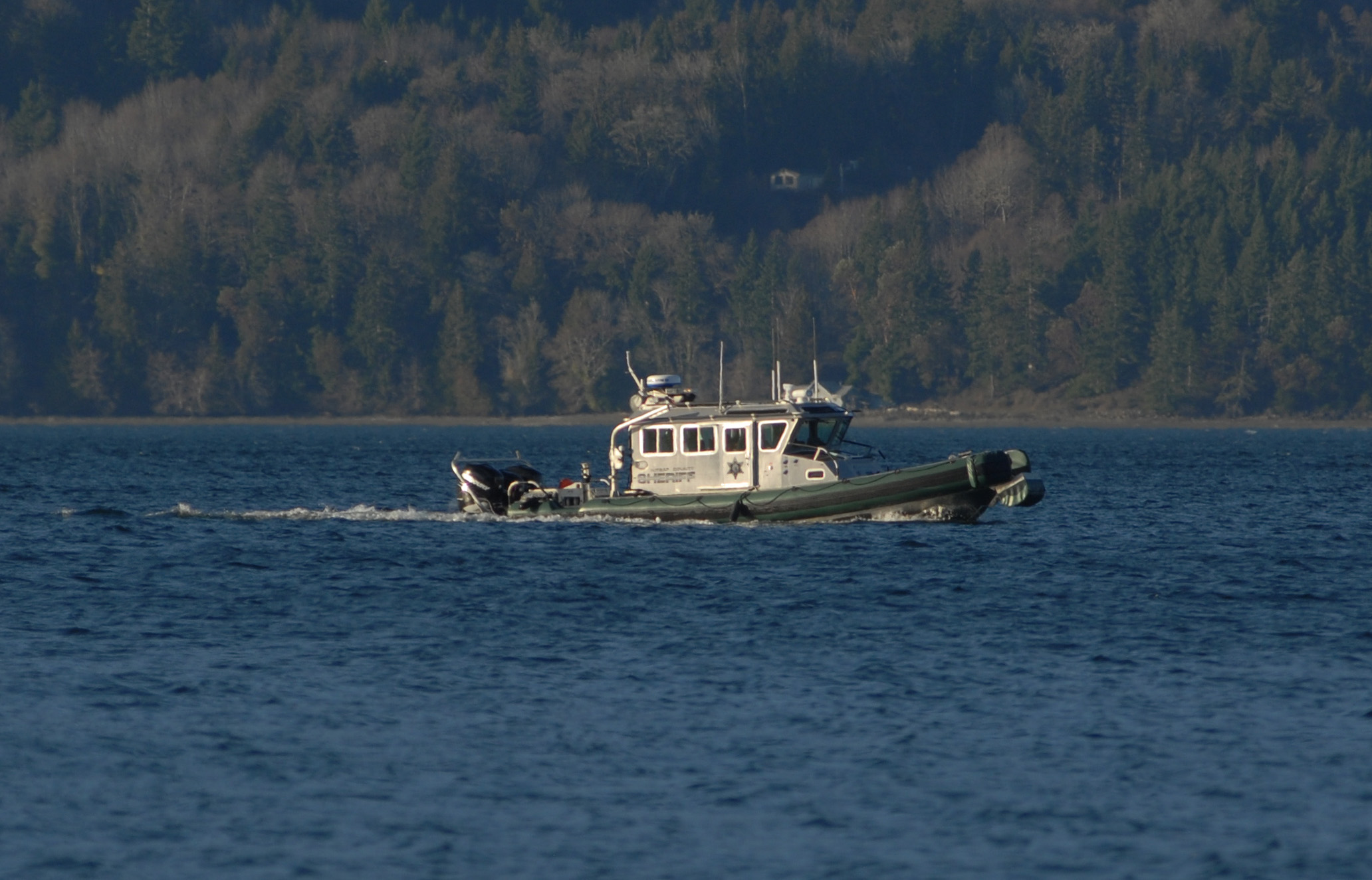 A Kitsap County Sheriff's Office patrol boat motors in the waters of Hood Canal south of Seabeck on Monday while searching for a downed plane. (Chris Tucker/Central Kitsap Reporter)