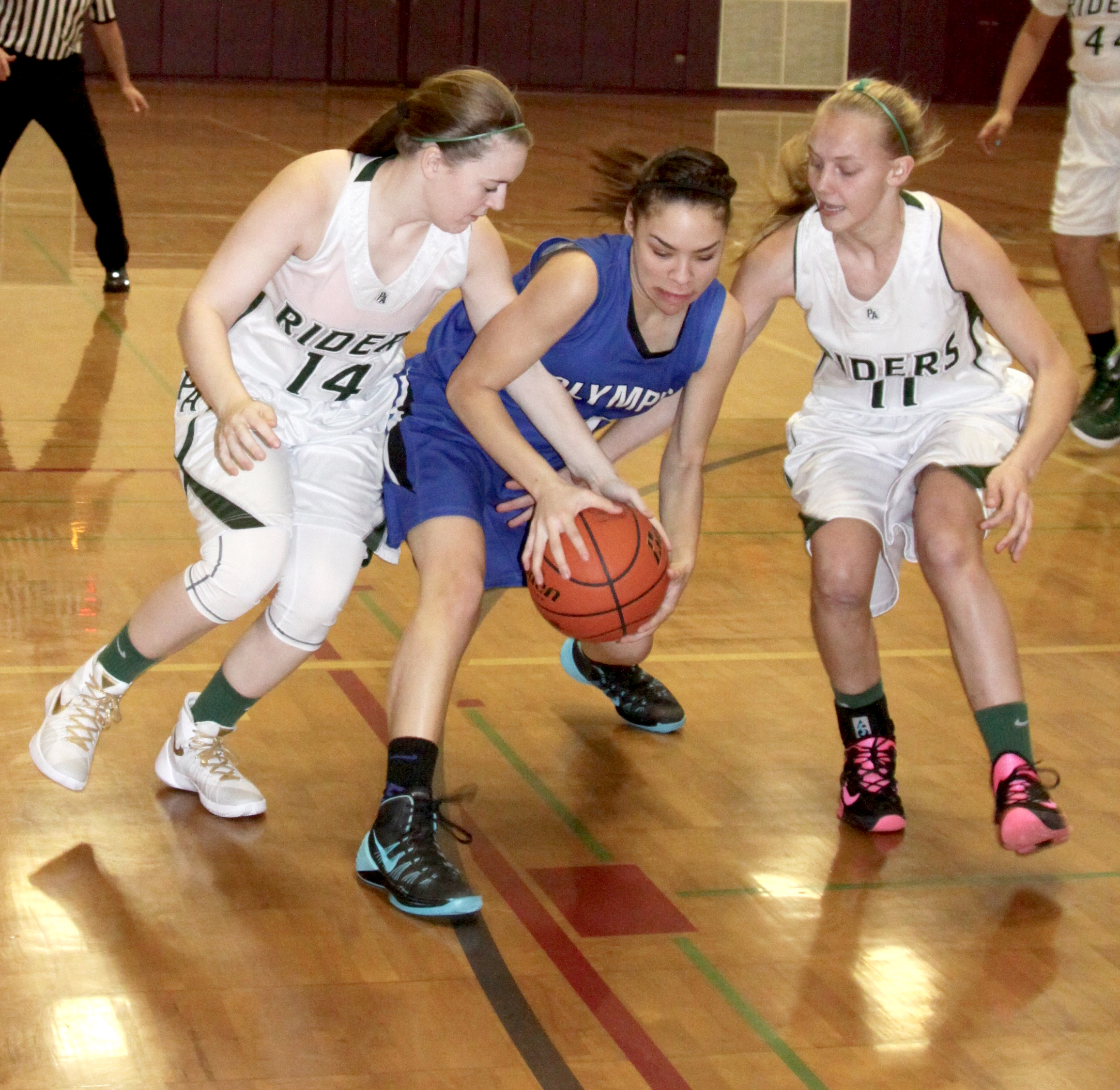 Port Angeles's Lauren Lunt (14) and Maddie Boe (11) reach for the ball against Olympic's Dejah Coleman. (Dave Logan/for Peninsula Daily News)