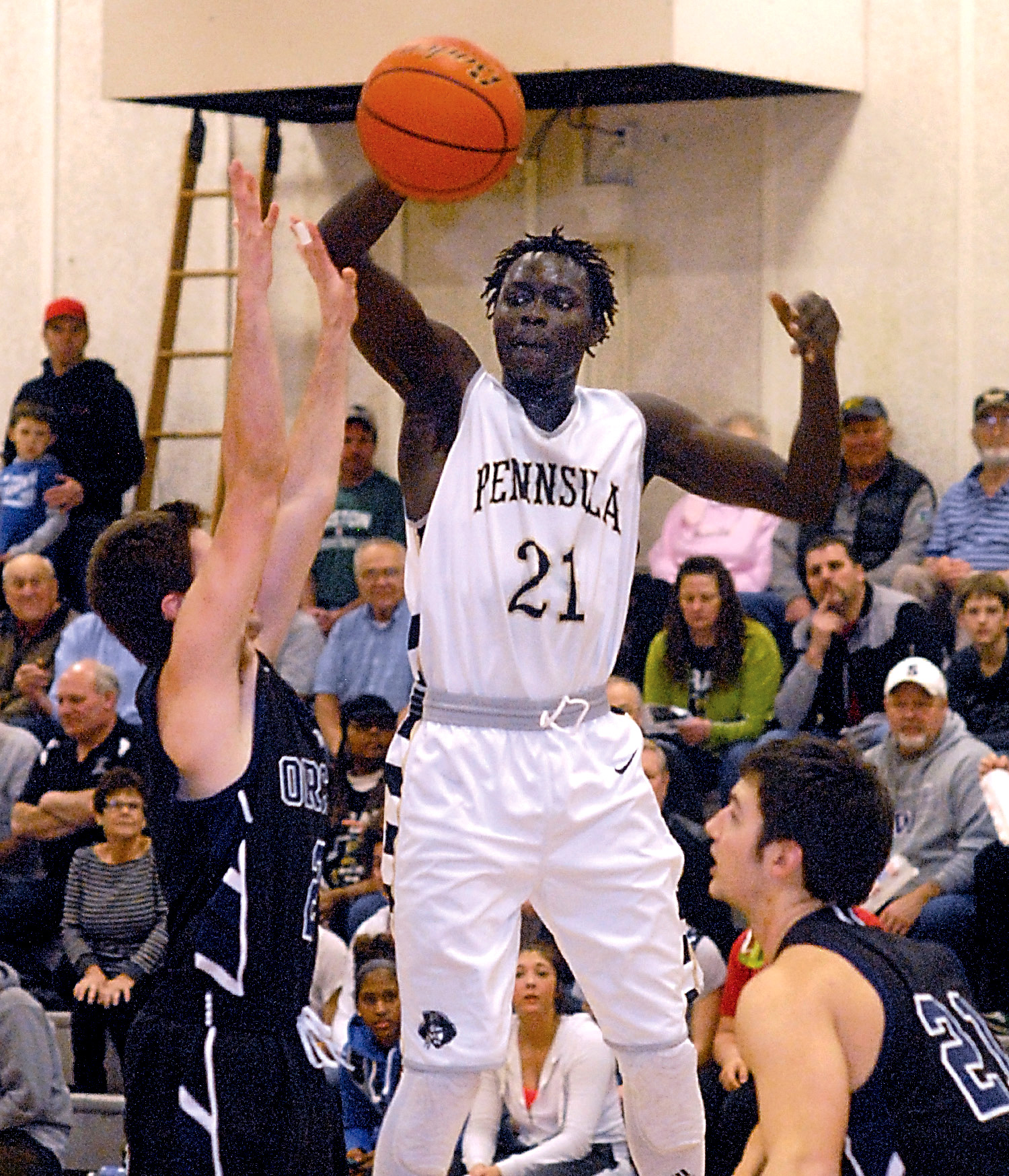 Peninsula's Jai Deng (21) leaps up and over Whatcom's Evan Miksovsky