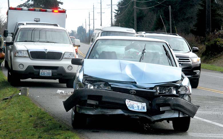 A car sits with a crumpled front end after it collided with a pickup truck on Old Olympic Highway at Lewis Road east of Port Angeles on Friday morning. (Keith Thorpe/Peninsula Daily News)