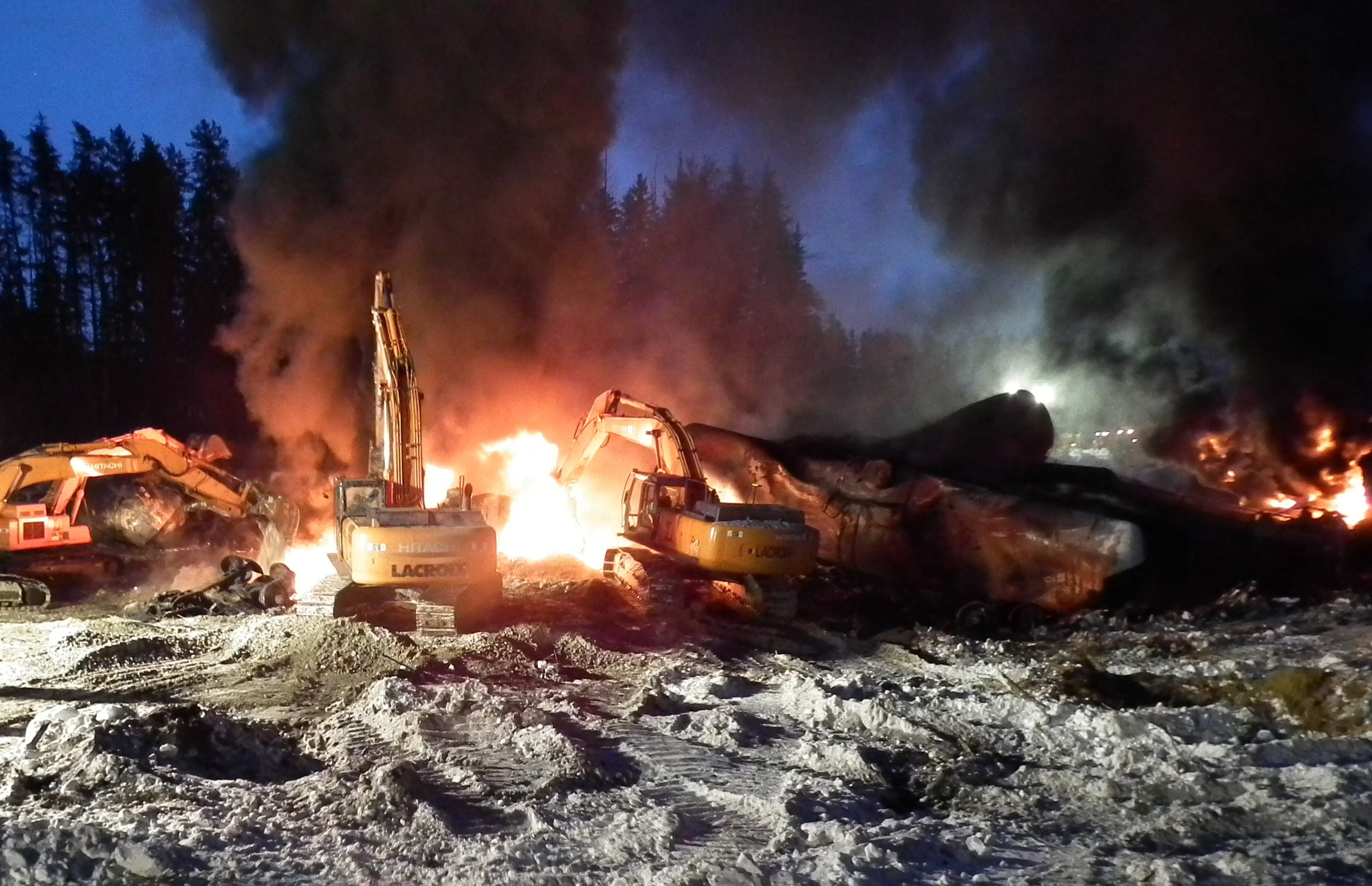 Workers fight a fire last Monday after a crude oil train derailment south of Timmins