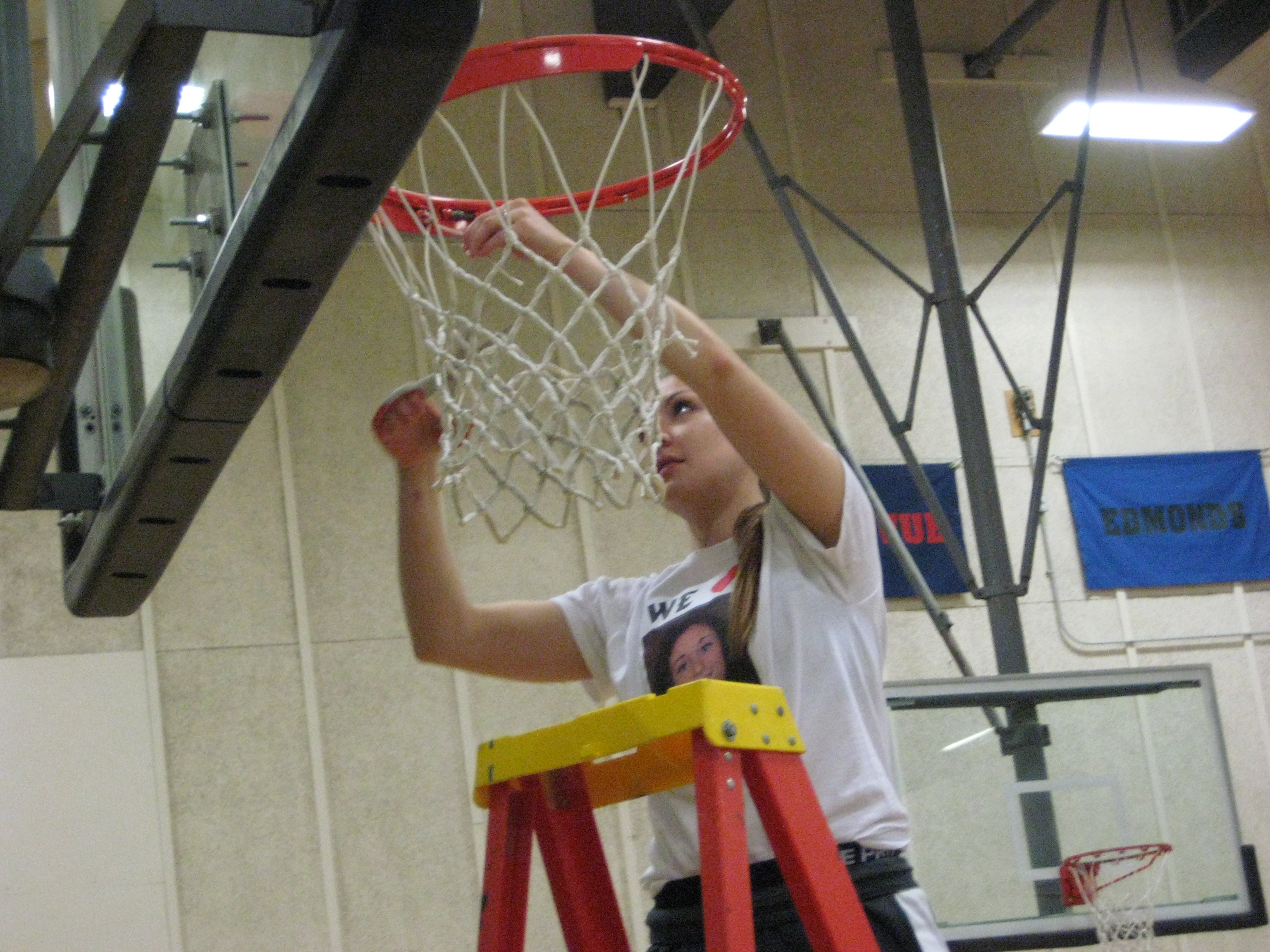 Neah Bay graduate and Peninsula College freshman Cherish Moss cuts off a piece of the net in honor of the Pirates winning the NWAC North Region championship. (Lee Horton/Peninsula Daily News)