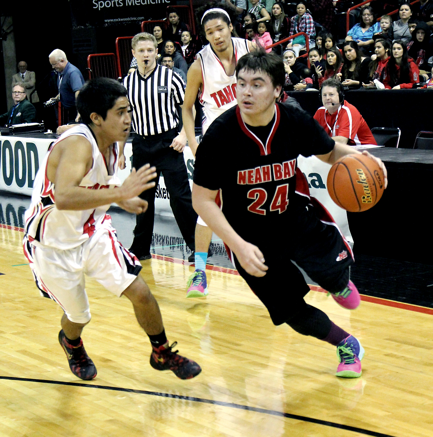 Neah Bay senior Ryan Moss drives the baseline against Taholah junior Brett Orozco during the second quarter of Thursday's 1B state tournament contest. (Roger Harnack/The Daily Sun News)