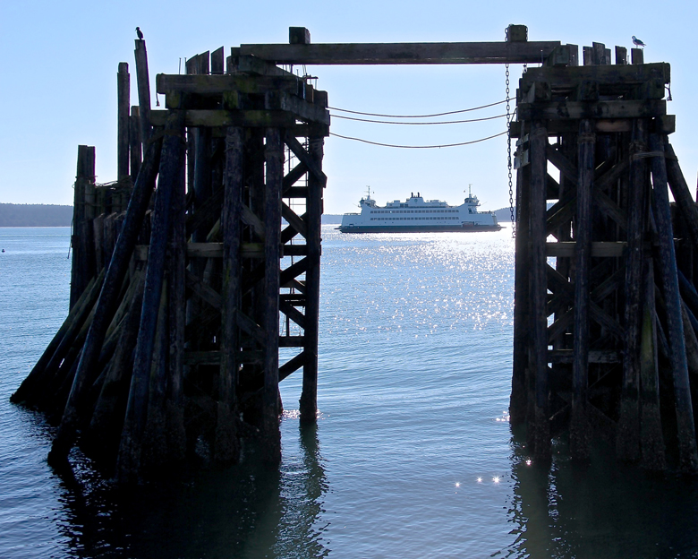 Shimmering waters and a state ferry are framed in one of the photographs exhibited at the Dungeness River Audubon Center in Sequim's Railroad Bridge Park. (Gary Lange)