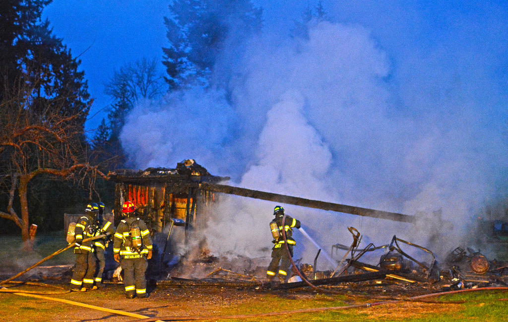 Clallam County Fire District 2 firefighters extinguish flames in a garage on Marsden Road. (Clallam County Fire District 2)