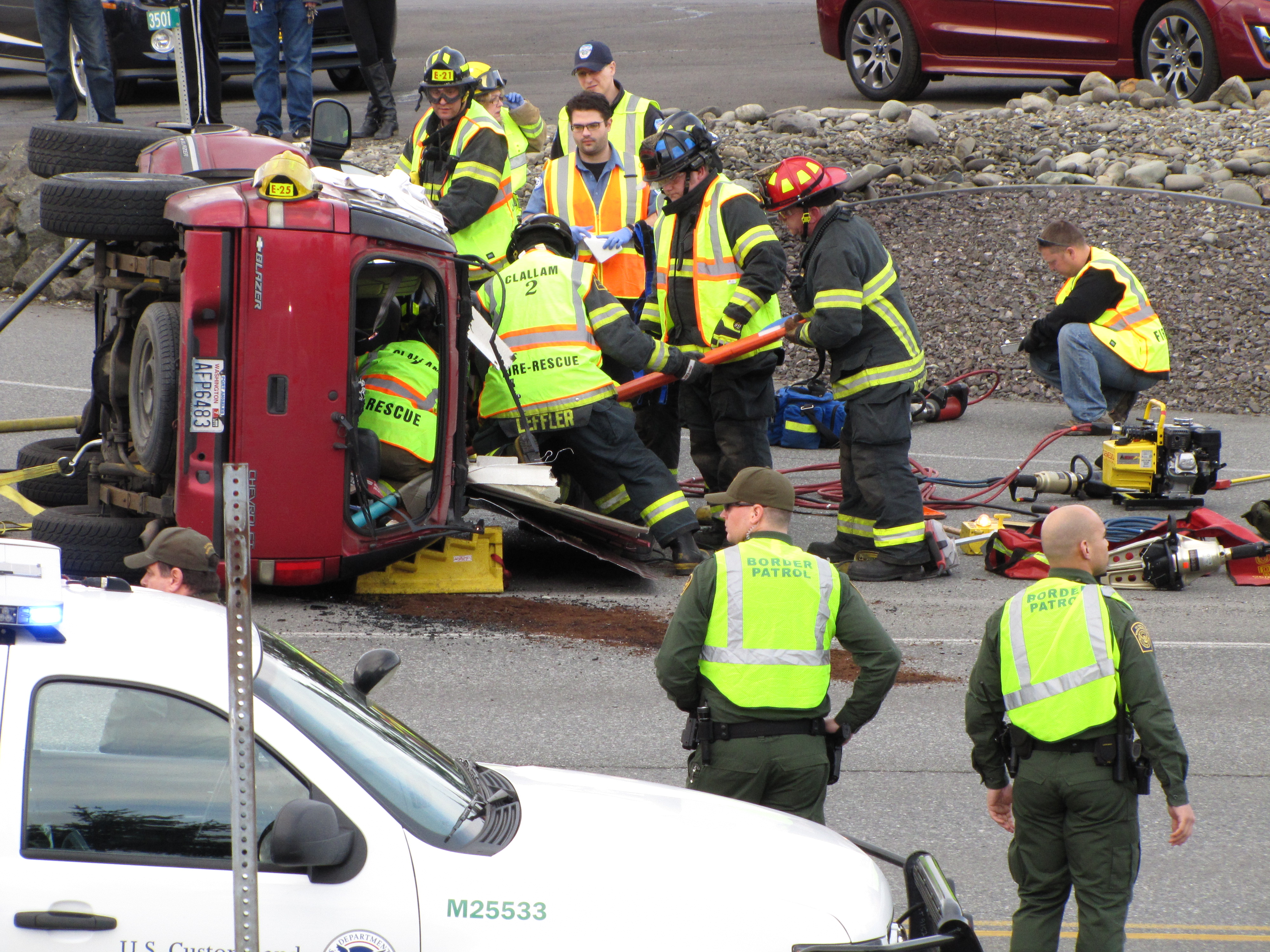 FIrefighters from Clallam County Fire District No. 2 work to free a 63-year-old woman from a Chevrolet Blazer after a rollover wreck on U.S. Highway 101 at North Masters Road on Sunday. (Arwyn Rice/Peninsula Daily News)