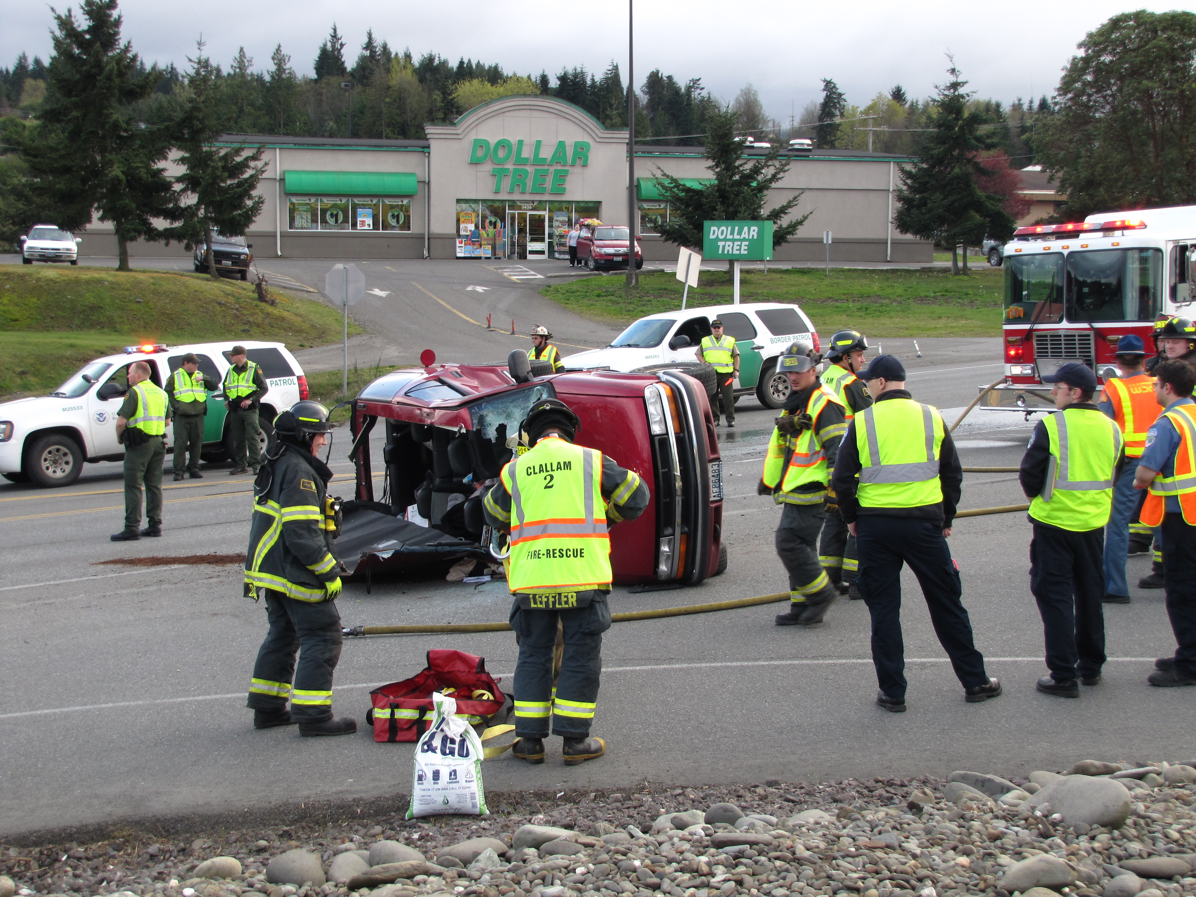 Firefighters from Clallam County Fire District No. 2 work to clear the scene of a rollover wreck at U.S. Highway 101 and North Masters Road on Sunday. (Arwyn Rice/Peninsula Daily News)