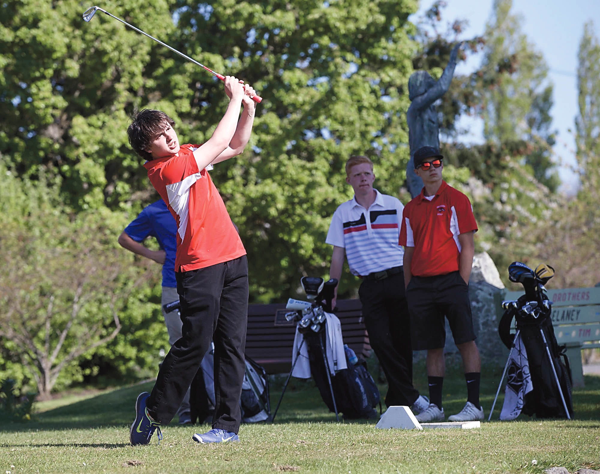 Port Townsend's Zack Glover tee's off on the par-3 seventh hole during a match against Chimacum on Monday at Port Townsend Golf Club. Looking on are Chimacum's James Porter