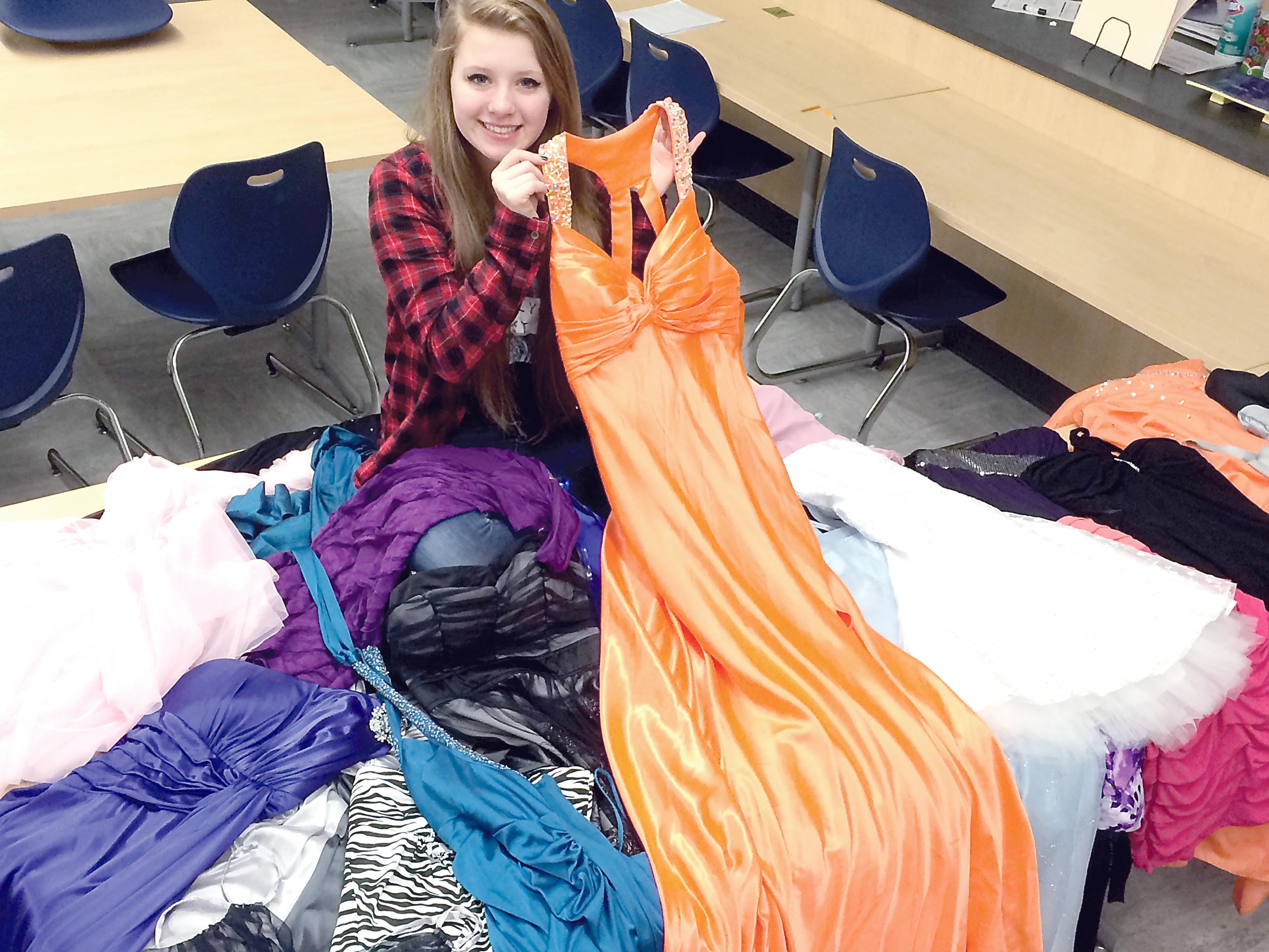 Lauren Decker shows a selection of the Wish Upon A Wardrobe dresses available to Forks High School students for prom. Decker