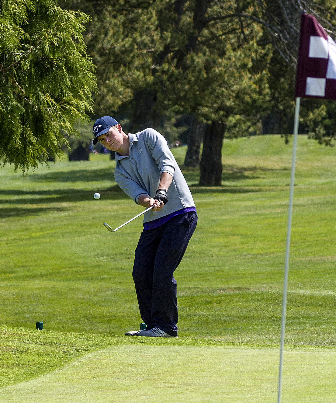 Sequim's Jack Shea chips his third shot onto the green on the sixth hole during the Olympic League golf championship at Cedars at Dungeness. (George Leinonen/for Peninsula Daily News)