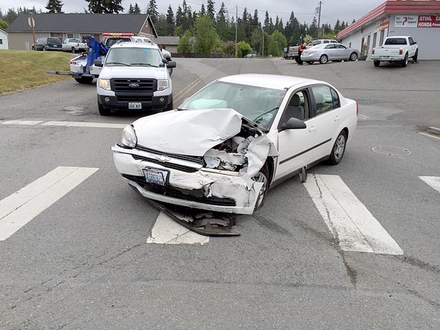 A white Chevy Malibu driven by Margaret Breeden of Port Angeles sits in the intersection of Brook Avenue and U.S. Highway 101 east of Port Angeles after it struck another vehicle just after noon Thursday. Drivers of both vehicles received non-life-threatening injuries and were transported to Olympic Medical Center in Port Angeles. (Dan Huff/Clallam County Fire District No. 2)