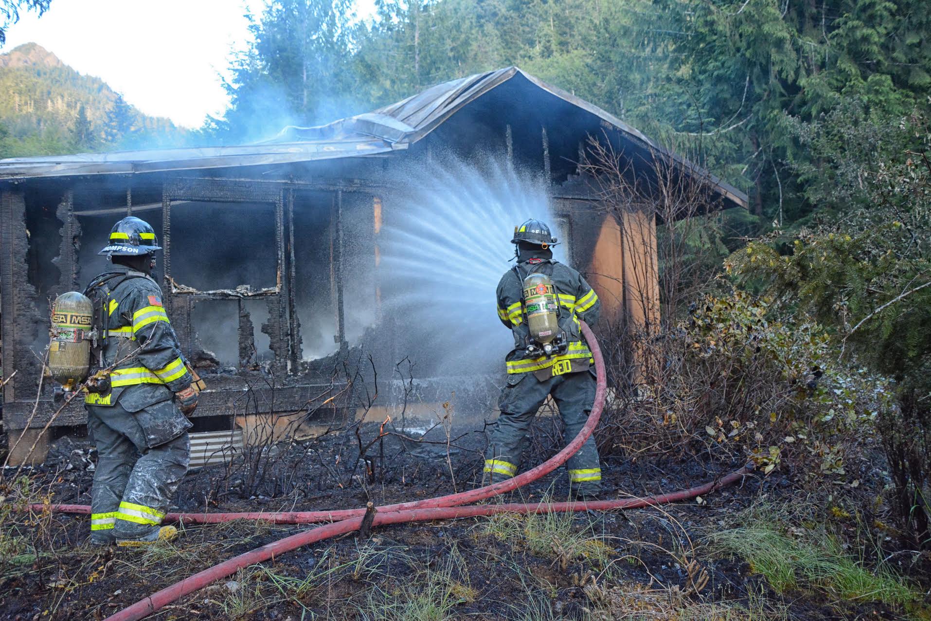 District 2 Fire-Rescue firefighters hose down an employee housing building at the Lake Crescent Lodge complex on Tuesday evening. (Jay Cline/District 2)