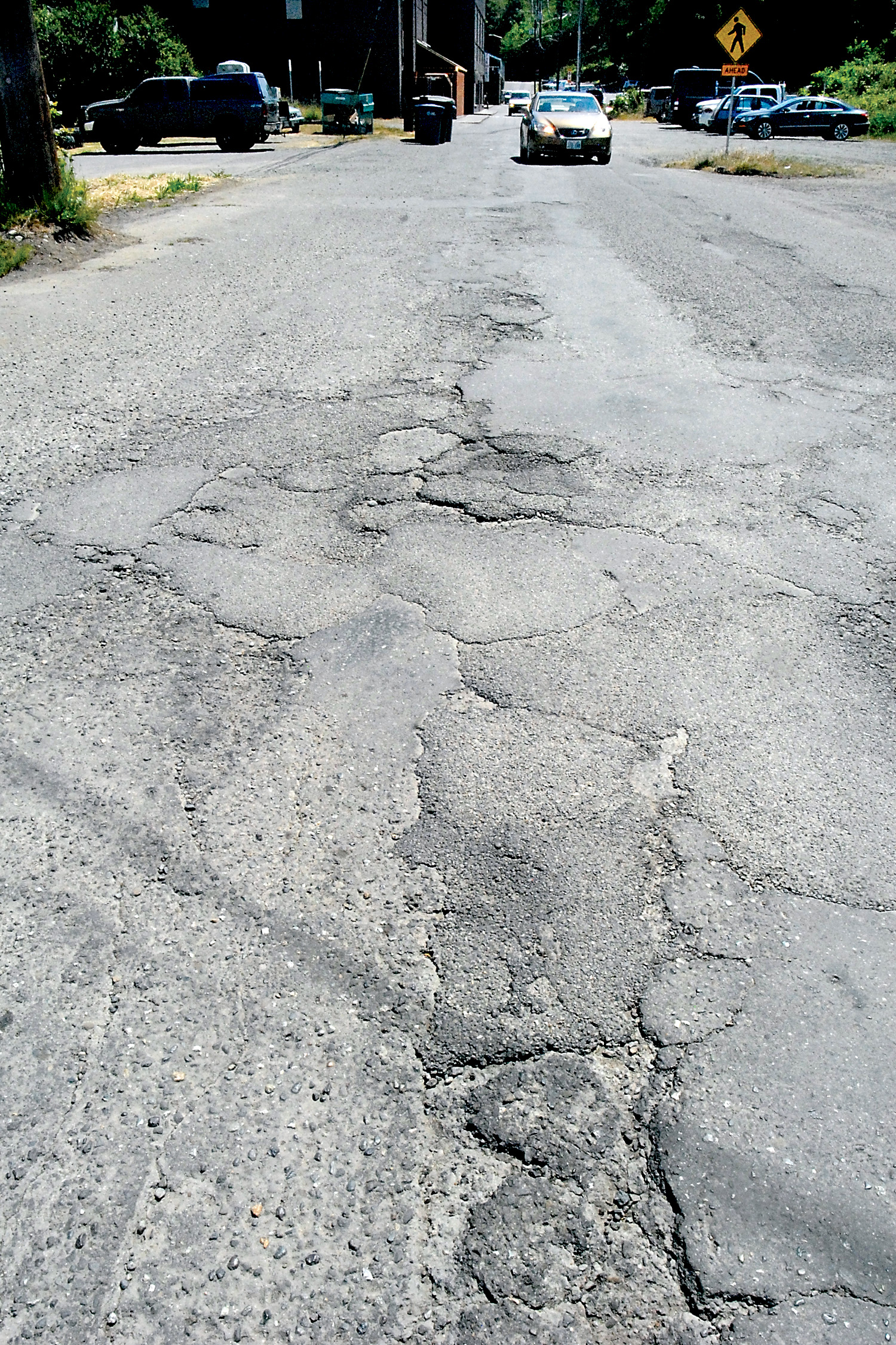 A patchwork of road surface material creates a rough section of the alley between Oak and Valley streets in downtown Port Angeles. (Keith Thorpe/Peninsula Daily News)