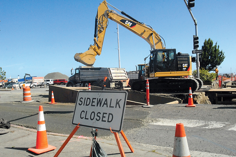 An excavator pulls dirt from a trench at the intersection of Front and Oak streets in downtown Port Angeles on Wednesday as part of the city's combined sewer outflow project. (Keith Thorpe/Peninsula Daily News)