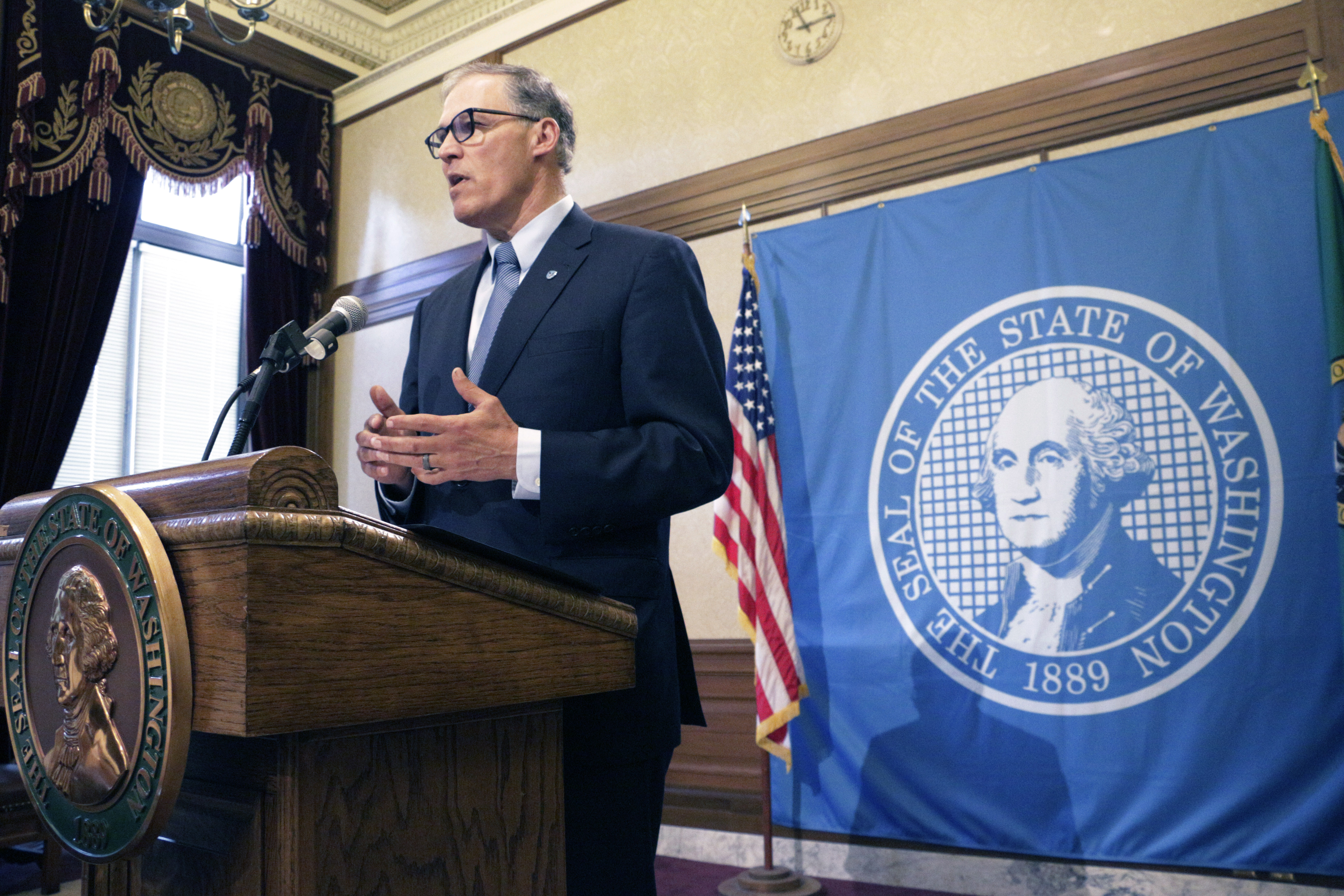 Gov. Jay Inslee talks to the media about the status of ongoing state budget negotiations Friday in Olympia. (The Associated Press)