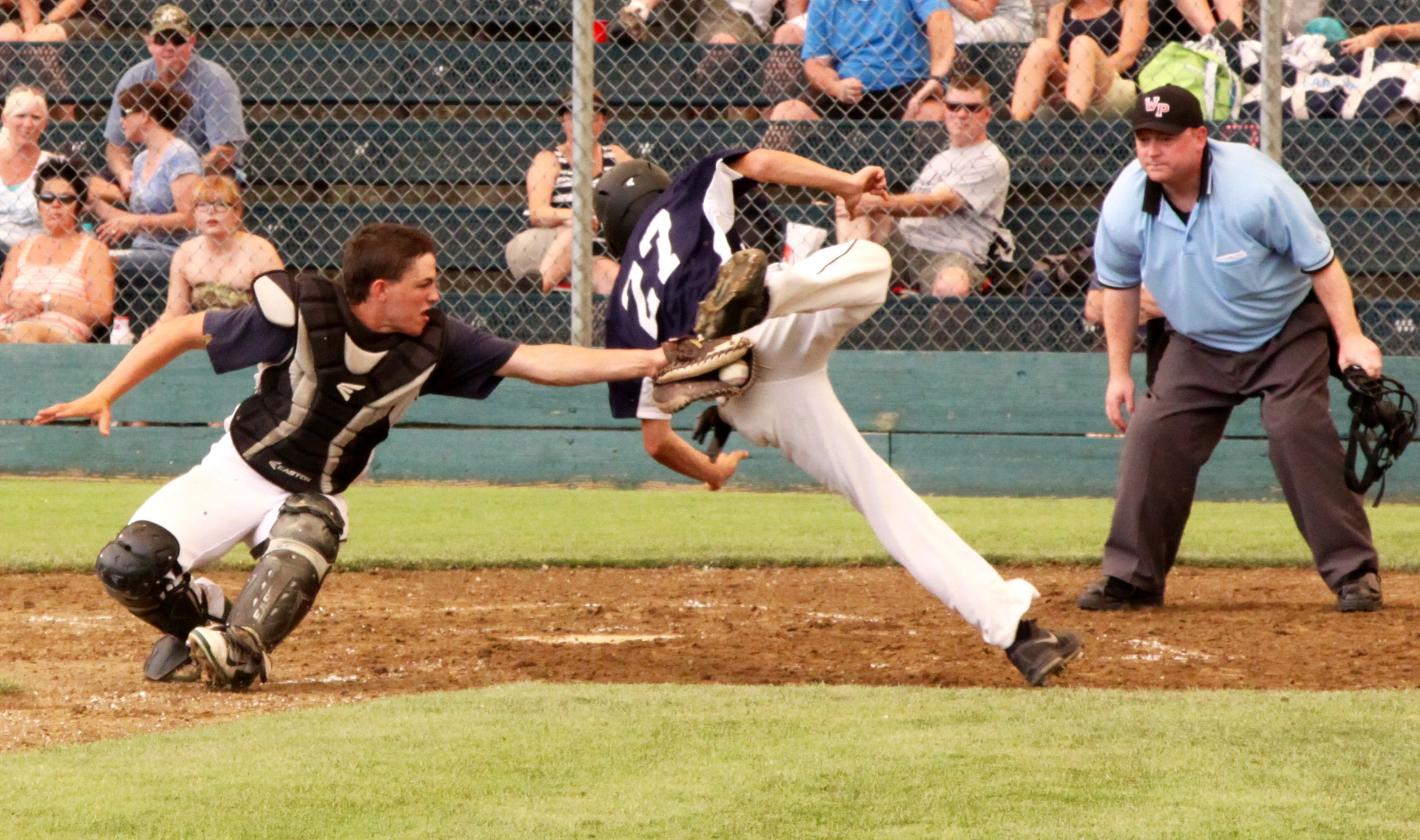 Wilder catcher Ricky Crawford tags out Laces 18U's Chase Hacker as he attempts to fly into home base on an attempted double steal. Dave Logan/for Peninsula Daily News