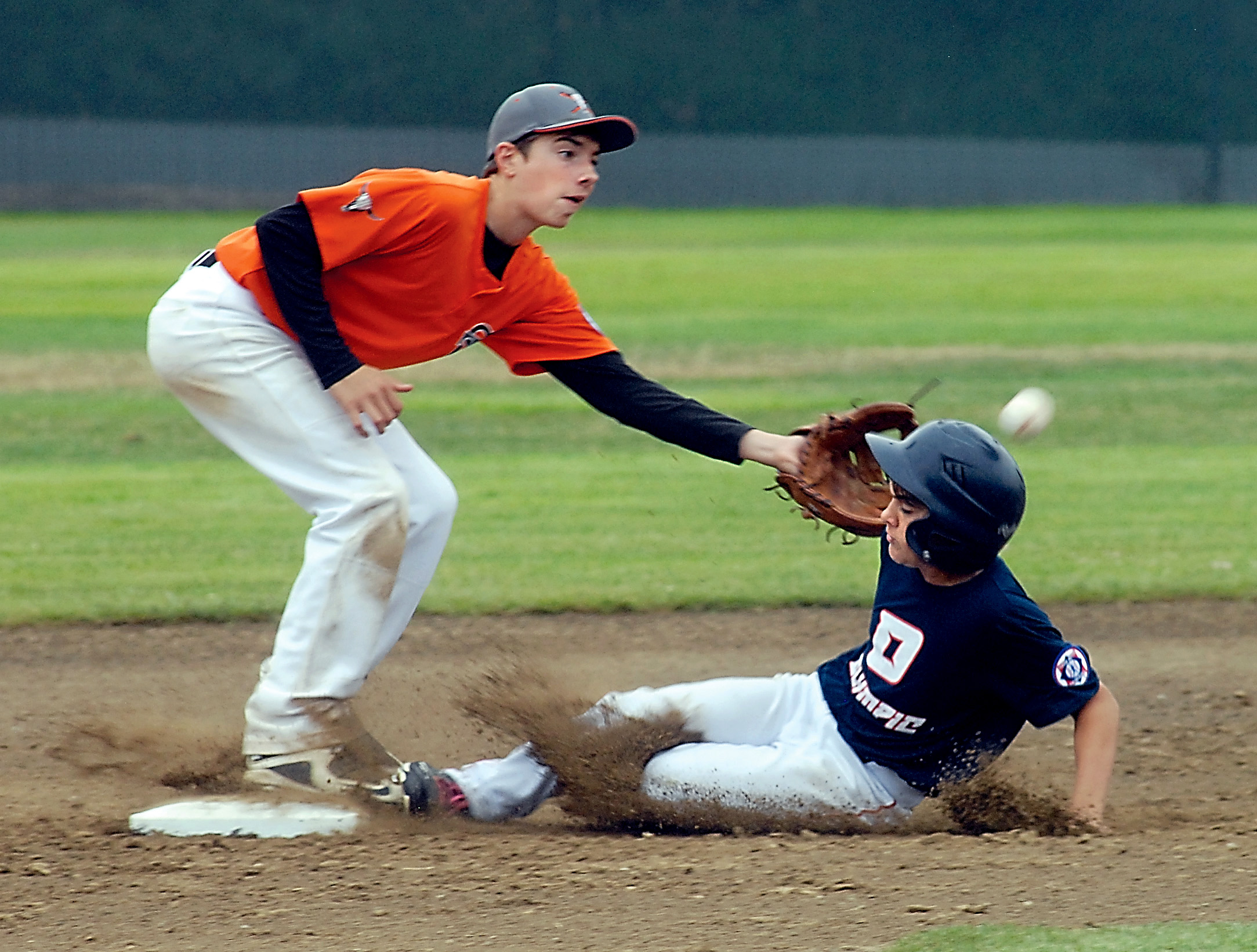 Olympic's Tyler Bowen is hit in the head by the ball as he slides into second ahead of the throw to Spokane's Matthew Schwarz. Keith Thorpe/Peninsula Daily News