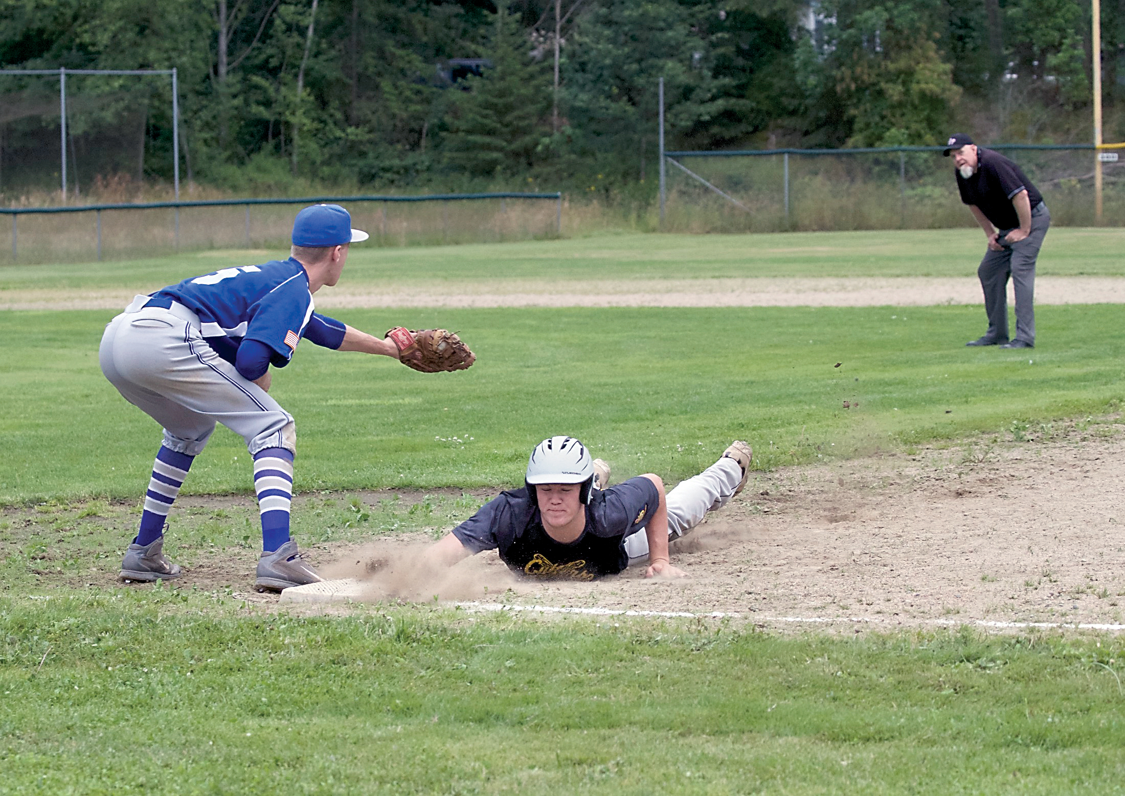 The Crosscutters' Dane Bradow makes it back to first during a game against the Olympic Tigers last week. (Steve Mullensky/for Peninsula Daily News)