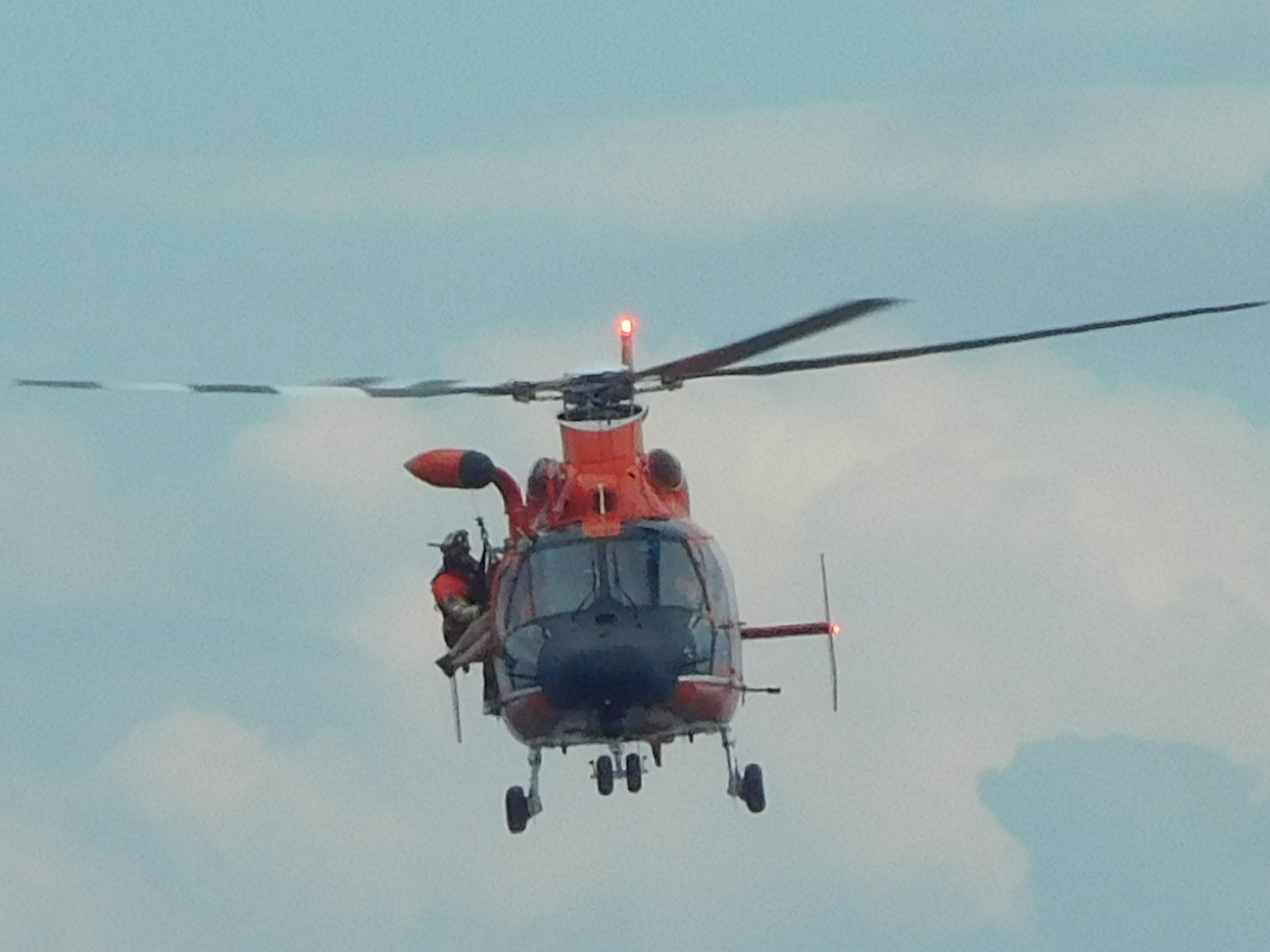 A Coast Guard rescue swimmer assists a helicopter crew in getting an injured kayaker into the helicopter Saturday. Clallam County Sheriff's Office