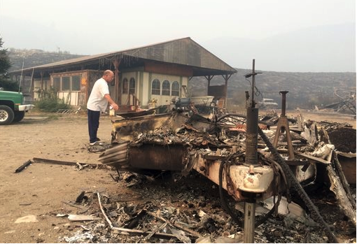 Steve Surgeon surveys the ruins after he lost everything he owned except his home in a wildfire on the outskirts of Okanogan on Sunday (Aug. 23). He said he stayed as the fire raced over a ridge and barreled down toward his home