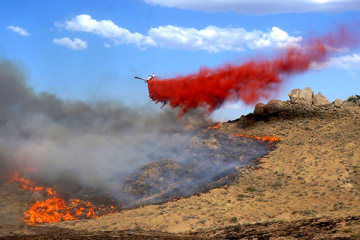 A firefighting plane drops retardant over a fire in Owyhee County