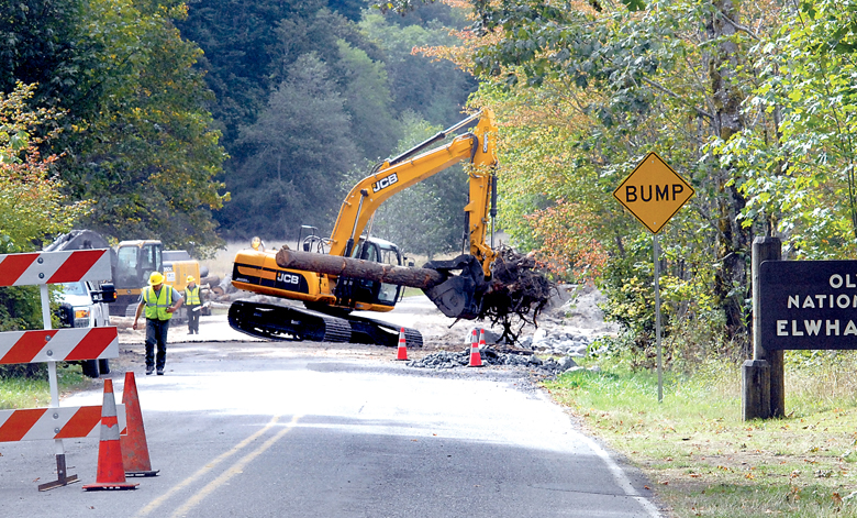 An excavator carries an uprooted log for placement along the bank of the Elwha River just inside the boundary of Olympic National Park near Port Angeles on Tuesday. Olympic Hot Springs Road is closed while crews reinforce the river bank next to the roadway. Keith Thorpe/Peninsula Daily News